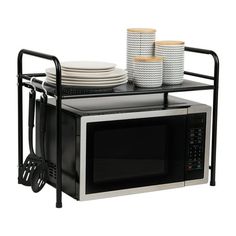 a microwave oven sitting on top of a metal rack with plates and cups in it