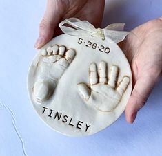 a ceramic ornament with a hand and foot imprint