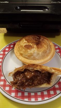 a piece of meat pie sitting on top of a plate next to a pot pie