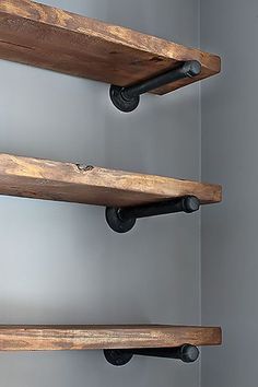 three wooden shelves with black metal handles