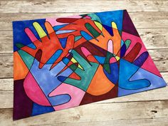 an art project made with colored paper on wooden boards, depicting colorful hands and fingers