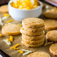 a stack of crackers sitting on top of a table next to a bowl of cheese