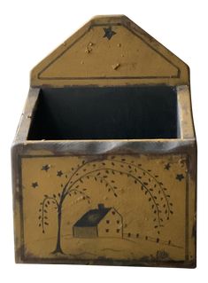 an old wooden box with a house and tree painted on the front, sitting against a white background