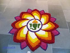 a colorful flower with a buddha face on it is shown in front of a tile floor