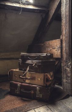 three suitcases stacked on top of each other in front of an open door and window