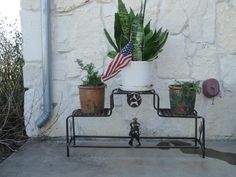 a potted plant sitting on top of a metal shelf next to a flag and other plants