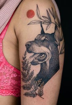 a woman with a tattoo on her arm and dog head in the middle of it