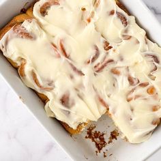 a close up of a cake in a pan with icing on top and other items around it