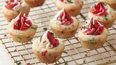 cupcakes with white frosting and sprinkles on a cooling rack