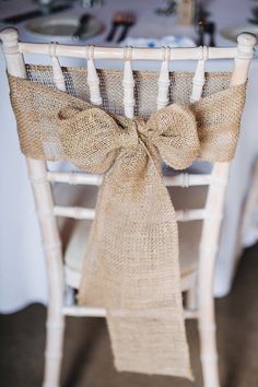 a chair with a burlap bow tied to it's back on top of a table