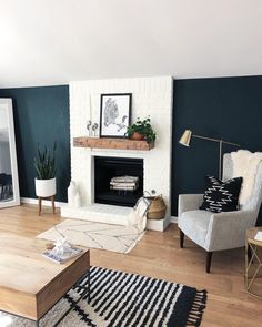 a living room with dark green walls and white furniture in the corner, along with a fireplace