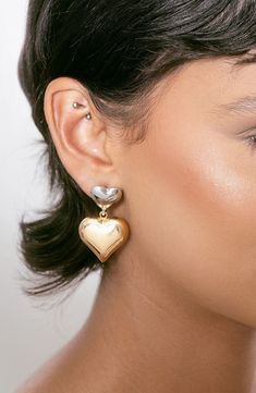 Two-tone hearts give versatile shine to drop earrings that move with you. 1 1/2" drop; 3/4" width Post back 18k-gold plate/rhodium plate Imported Silver Heart-shaped Gold-plated Earrings, Gold Double Heart Earrings For Formal Occasions, Gold Drop Jewelry For Valentine's Day, Silver Heart Earrings Tarnish Resistant, Gold Teardrop Heart Charm Earrings, Gold Dangle Heart Earrings For Formal Events, Gold Plated Silver Heart Earrings For Anniversary, Silver Tarnish Resistant Heart Earrings, Gold Double Heart Sterling Silver Earrings