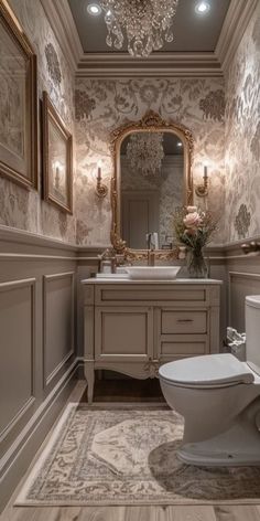 a bathroom with a toilet, mirror and chandelier above the sink in it