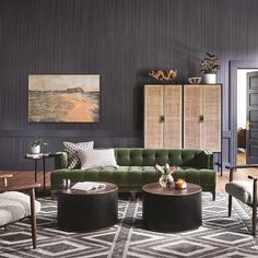 a living room filled with lots of furniture next to a wall covered in black and white paintings