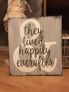 a wooden sign that says they lived happily everafter on the side of a table