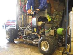 a man standing next to an atv in a garage