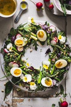 a white plate topped with an egg and veggie wreath