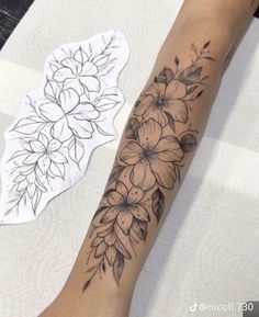 a woman's arm with flowers on it and a sticker next to it