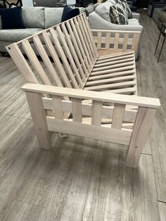 a wooden bed frame sitting on top of a hard wood floor in a living room