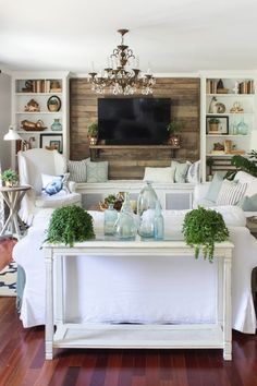 a living room filled with furniture and a flat screen tv mounted on the wall above it