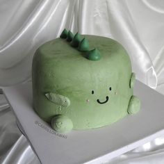 a green cake sitting on top of a white table