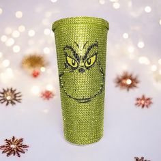 a green plastic cup with a grin face on it and snowflakes in the background