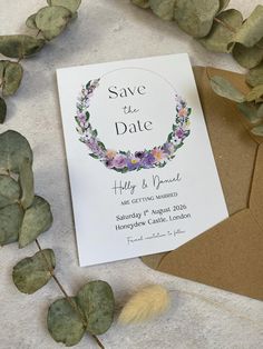 save the date card with flowers and leaves on it next to an envelope that says,'save the date '