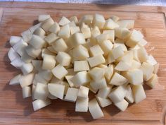 chopped potatoes on a cutting board ready to be cut into wedges or cubes