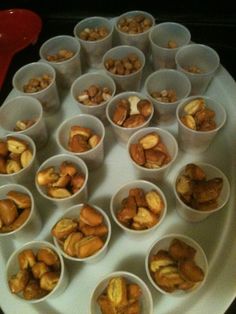 many small bowls filled with nuts on a white plate