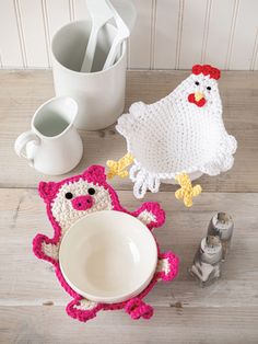 two crocheted chicken dishes next to a mug