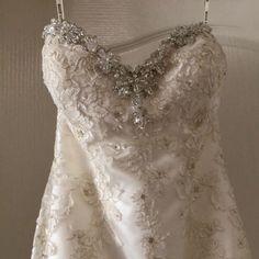 a white wedding dress hanging on a wall