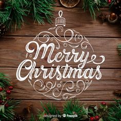 merry christmas lettering on wooden background with pine cones and oranges in the foreground