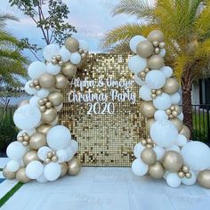 balloons and streamers decorate the entrance to a new year's eve celebration in front of a gold sequin backdrop