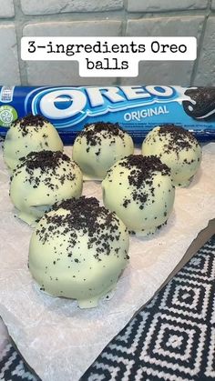 four oreo balls are on a table with chocolate sprinkles