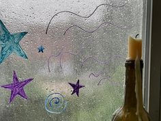 a bottle and candle sitting on a window sill