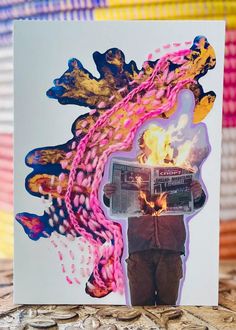 a card with a man holding a newspaper in front of a fire and flames design