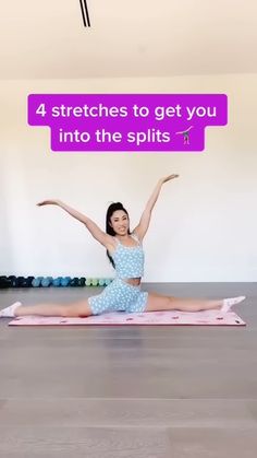 a woman is sitting on a yoga mat with her arms in the air while stretching