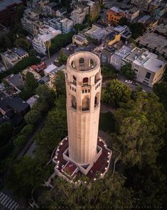 an aerial view of a tall tower in the middle of a city with lots of trees and buildings around it