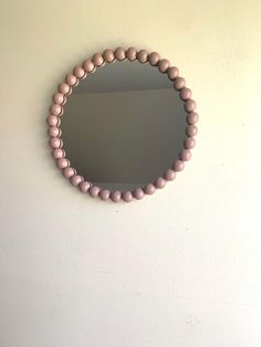 a round mirror mounted to the side of a wall