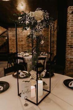 a centerpiece with flowers and candles on a table