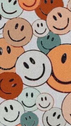 many different colored smiley faces on a white surface