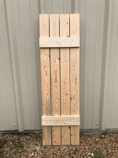 a wooden door sitting in front of a metal wall next to a pile of dirt