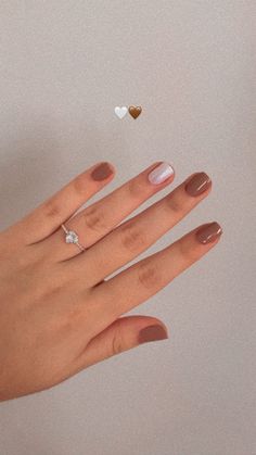 a woman's hand with two hearts and a diamond ring on her left finger