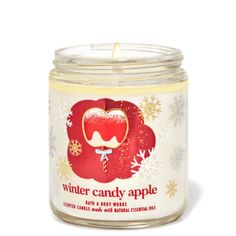 a candle that is sitting in front of a white background with snowflakes on it