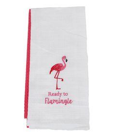 a white towel with a pink flamingo embroidered on the front and red trim around it