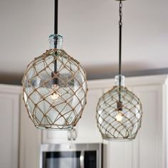 two glass globe lights hanging from a kitchen ceiling