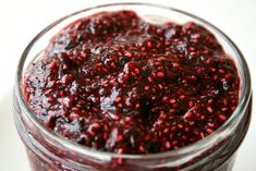 a glass jar filled with cranberry sauce on top of a table