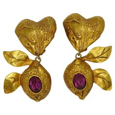 CHRISTIAN LACROIX vintage textured gold tone dangling earrings (clip-on) featuring a heart top and a lemon embellished with an oval fuchsia colour crystal. Marked CHRISTIAN LACROIX CL Made in France. Indicative measurements : max. height approx. 7.2 cm (2.83 inches) / max. width approx 3.9 cm (1.54 inches). Weight per earring : approx. 37 grams. Materials : Gold tone metal hardware / Crystal. Good vintage condition (Grade : B). Wear consistent with age and use. Little gilt rubbing on a side of a lemon (see picture 8). Some friction wear on the junction rings (see pictures 9 and 10). Minor oxidation on the reverse sides. Micro chips on the crystals (need very close inspection to be noticed). NOTES - This is a preloved vintage item, therefore it might have imperfections. - Colors may differ Crystal Notes, Christian Lacroix Jewelry, Nepo Baby, Forever Red, Heart Top, Earrings Clip, Maximalism, Vintage Texture, Fuchsia Color