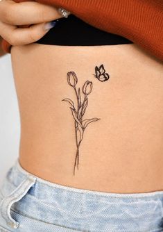 a woman's stomach with a flower tattoo on it