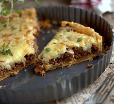 a piece of pizza sitting on top of a pan covered in cheese and meats